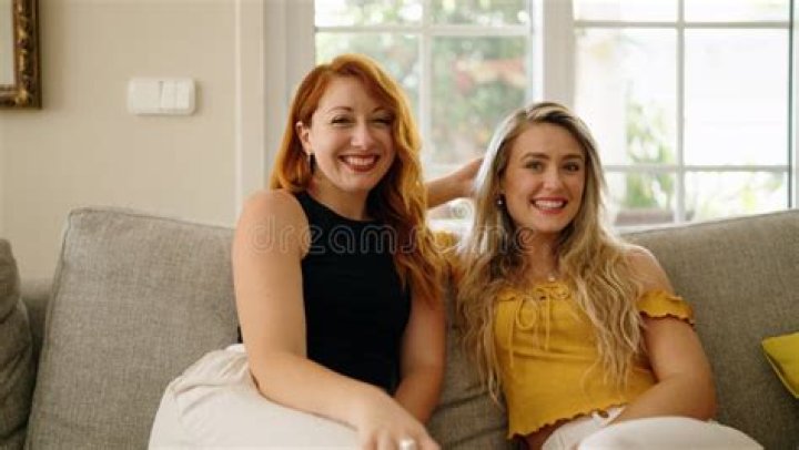 two women sitting on a couch in a living room